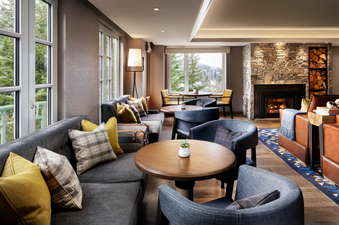 A cozy lounge area in the Fairmont Chateau Gold King Room with a fireplace and comfortable seating.