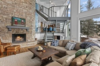 The living room of Pinnacle 1688 features a stone fireplace and comfortable seating.