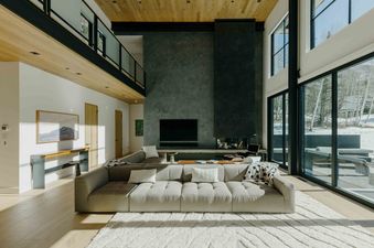 A modern living room with a large sectional sofa and a fireplace