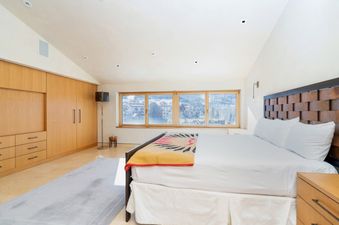 Bedroom at Peaks Penthouse 851 with large windows and wooden headboard.