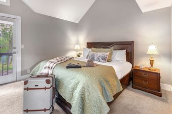 The bedroom is beautifully staged with a vintage suitcase.