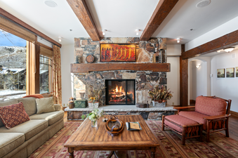 Grand Lodge Three Bedroom Deluxe 404 living room with a large stone fireplace, a couch, a chair, and a coffee table.