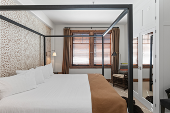 The master bedroom in Grand Lodge Four Bedroom 306 features a king size bed with a canopy and a large window that lets in plenty of natural light.