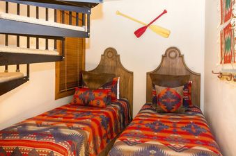 Two twin beds with colorful southwestern bedding, and a wooden headboard.