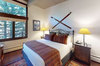 A bedroom with a large window with a view of the mountains.