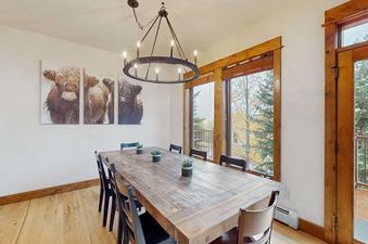 Dining area with a large wooden table and views of trees at EagleRidge Townhomes 1455.
