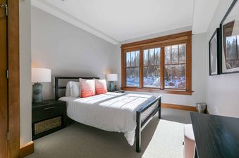 A bedroom with a bed and a window with a view of the mountains.