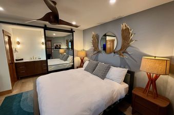 Modern bedroom at Lodge at Steamboat F303 with a plush bed, rustic moose antler decor, and a sliding mirrored door.