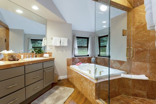 A luxurious bathroom with marble accents, a soaking tub, and a glass-enclosed shower.