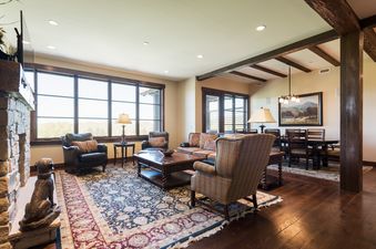 A spacious and elegantly furnished living room at Silver Star 1302 with large windows, a fireplace, and an adjacent dining area.