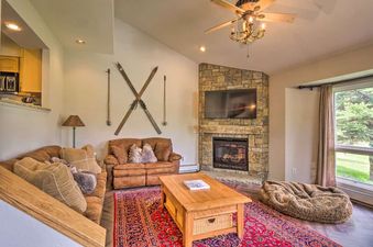 Cozy living room with fireplace and brown sofas in Copper Mountain Home with Hot Tub.