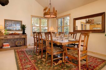 The dining table and chairs in the warm, cabin-style dining area at Moose Creek 31.