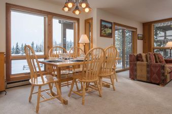 The dining room at Nez Perce C4 featuring a wooden table, chairs, and scenic snowy views.
