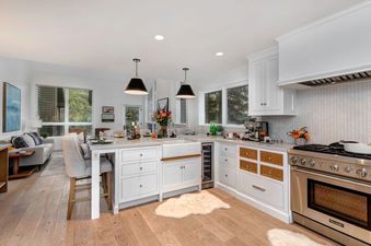 The Abode in Red Pine features a modern kitchen with white cabinets, stainless steel appliances, and hardwood floors.