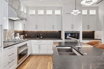 The kitchen in Solaris 6DE has stainless steel appliances, dark countertops, and white cabinets.