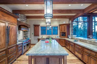 The kitchen at Two Trails features wooden cabinets, granite countertops, and a large island.
