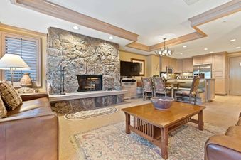 Cozy living room in Lodge Tower 478 2BR with a stone fireplace and comfortable seating.