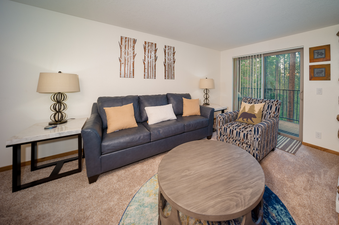The living area at Beaver Village 1714 features a comfortable blue sofa and a patterned armchair.