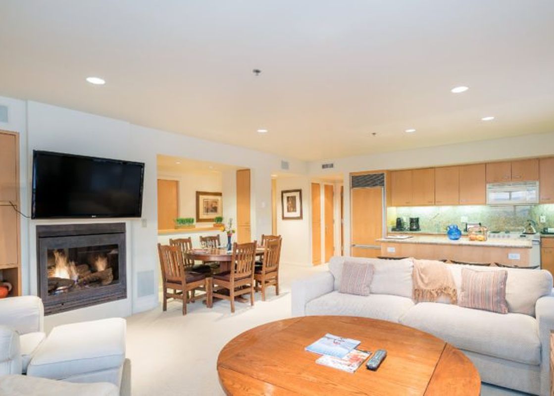 Living area of Penthouse At The Peaks 746 with fireplace, kitchen and dining area.