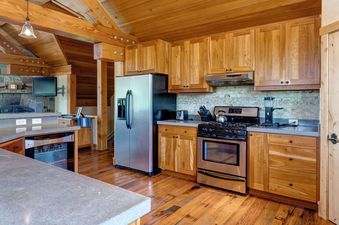A rustic kitchen at Skyline Jackson Hole with wooden cabinets and stainless steel appliances.