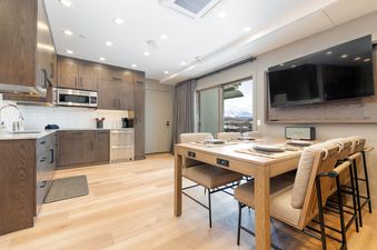 Signature Suite 518 features a contemporary kitchen with stainless steel appliances and a dining area with a table and chairs.