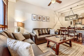A living room space in BlueSky Breckenridge 513 with a brown leather sofa and a wooden coffee table.