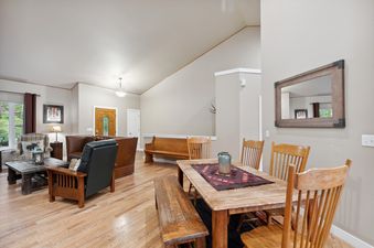 A spacious open-concept dining and living area in Suncrest Hideaway with rustic wooden furniture and comfortable seating.