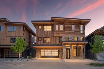 The Riverlight Lodge is showcased in an eye-level, eye-catching exterior shot at dusk, highlighting its modern mountain architecture against a colorful sky.
