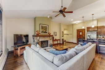 The comfortable and spacious living room at Water House on Main Street 5404 featuring a stone fireplace and a large sectional sofa.
