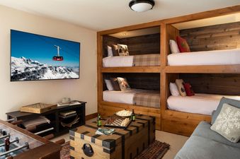 Bunk bedroom in Granite Ridge Lodge 17 featuring built-in bunk beds, a large TV, a foosball table, and a cozy seating area.