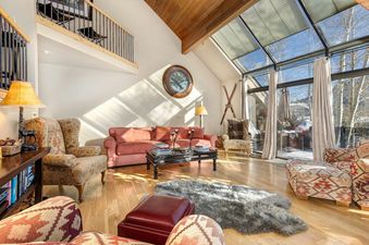 The living room at Deer Valley Delight has a large leather sofa, a wood coffee table, and multiple chairs, perfect for relaxing after a day on the slopes.