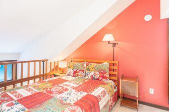 A bedroom in Manitou Lodge 9 featuring a quilt bed, bedside tables, and warm lighting.