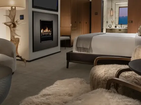 The Vista Suite Yellowstone is a luxurious retreat featuring a comfortable bedroom, a modern fireplace, and a cozy living area with stylish furnishings, creating a serene and sophisticated ambiance.