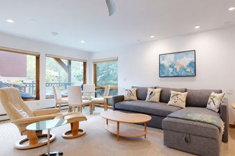 A modern and cozy Upstairs Den in Montaneros 222 featuring a comfortable grey sectional and a dining area.