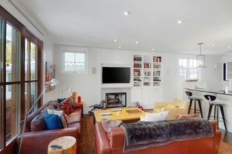 Living room with leather couches, a fireplace, and a view of the outdoors.