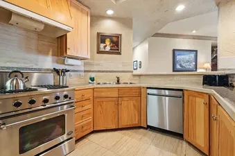 Well-equipped kitchen at Centrum 302 with wooden cabinets and stainless steel appliances.