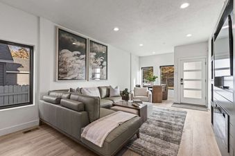 A living room with a large sectional sofa, coffee table, and a fireplace in the corner.