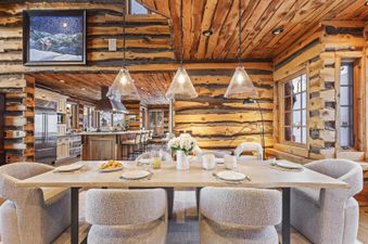 The dining table in The Treehouse in Canyons Village has a wood top and is surrounded by comfy, light gray chairs.