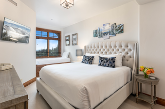 Grand Lodge Three Bedroom Deluxe 407 features a large, comfy king bed, a separate sleeping area with a full-size bed, and a stunning view of the mountains.