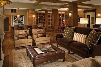 A luxurious and spacious lounge area in Buffalo Pass One Steamboat Place 409, featuring comfortable seating, a fireplace, and a bar area.
