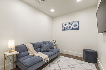 A cozy seating area at Horizon View with a blue futon, a side table with a lamp, a modern art piece, and a television.
