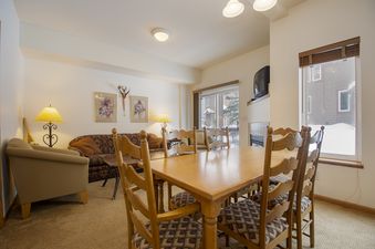 The open-concept living and dining area of Winterstar G3 is well-lit and features comfortable seating with a large wooden dining table.