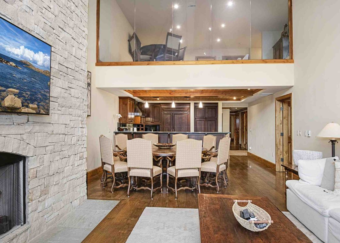 A large living area in Vail Mountain View 402, featuring a fireplace, large flat-screen TV, a large sectional sofa, and a coffee table.