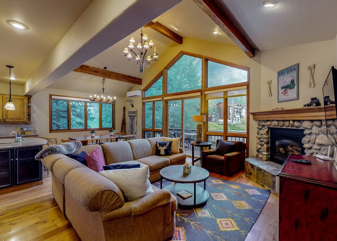 Cozy living area of Leeward 2688 with sectional couch and fireplace under vaulted ceilings.
