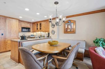 The dining area features a wood table and chairs, as well as a built-in bench.