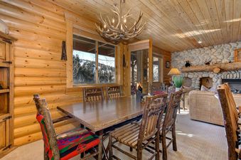 The dining area in Black Bear 305 Abode features log furnishings and large windows.