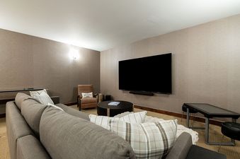 Cozy media room at Deer Valley East Basecamp with a large sectional sofa and wall-mounted TV.