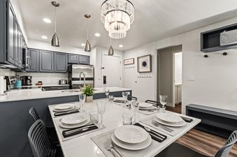 Dining table set for a meal next to the modern kitchen at Snow Flower 137.