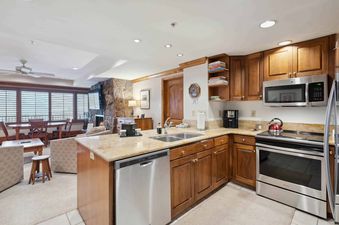 The kitchen in Lodge Tower 686 2 Bedroom features wooden cabinetry and stainless steel appliances.