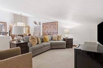 A welcoming living area at The Charter G230 with a large L-shaped sofa, end tables with lamps, and soft lighting.